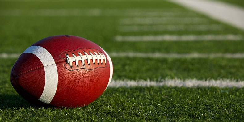 a closeup of a football sitting on a football field