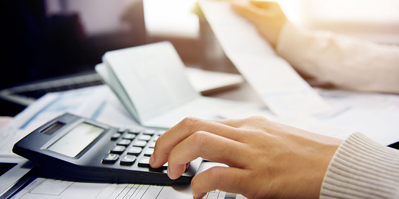 closeup of a woman's hand typing on a calculator